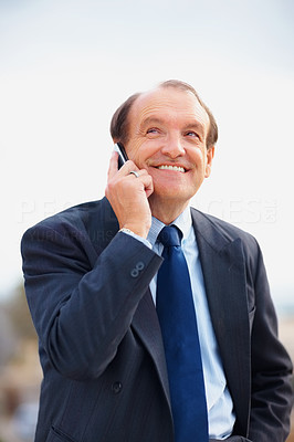 Senior business man on phone while looking up at copy space
