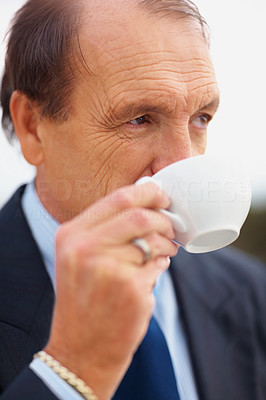 Closeup of a thoughtful senior business man drinking tea