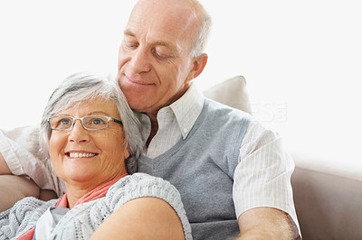 Relaxed smiling senior man and woman sitting on couch at home
