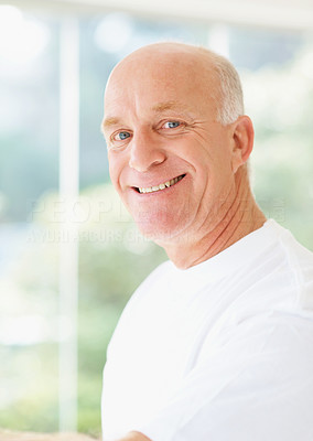 A happy handsome senior man smiling over a bright background