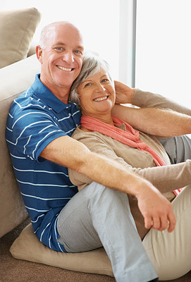 Portrait of a happy senior couple sitting together in house