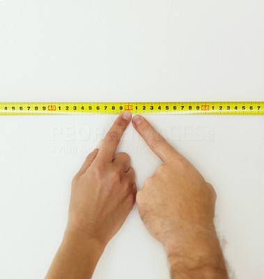 Closeup of a human fingers pointing at a measuring tape