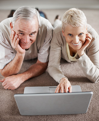 Old couple with a laptop computer lying on the floor