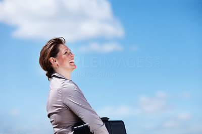 Happy business woman against the blue sky