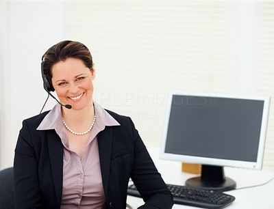 Happy business woman using a headset while at work