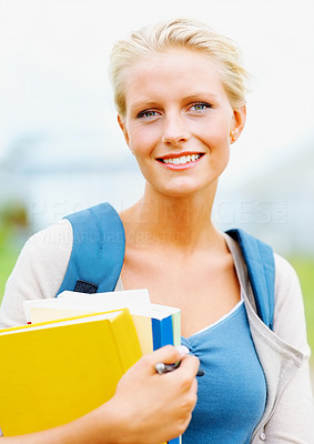 Happy young female student holding books , outdoors