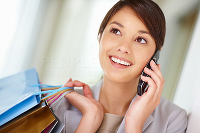 Beautiful young female with shopping bags speaking on the phone