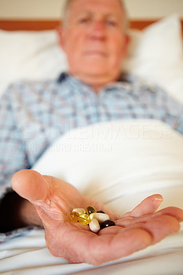Medical pills in the hand of an elderly man