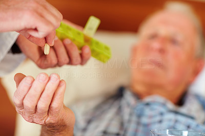 Elderly man being given a life saving pill by a doctor