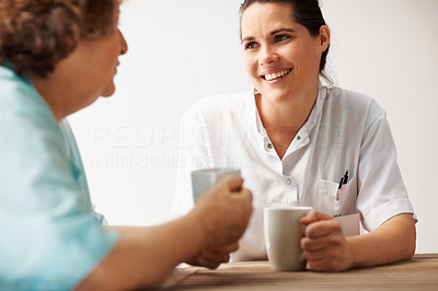 Pretty nurse having a cup of coffee with a patient