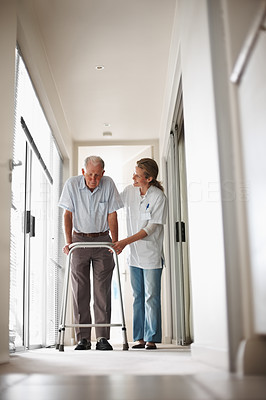 Doctor helping a senior man on a walker at the corridor