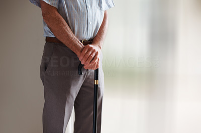 Mid section of a senior man with his walking stick
