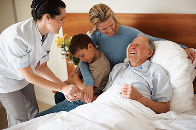 Happy senior patient being visited by family at the hospital