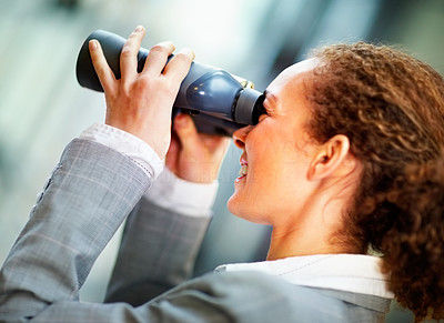 Young business woman looking through binoculars
