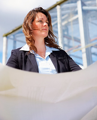 Business woman with blue prints at the construction site