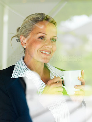 Business woman having coffee while looking outside window