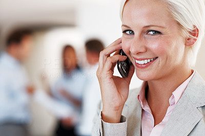 Smiling young lady using mobile phone at office