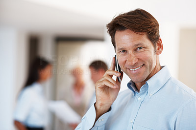Happy businessman using mobile phone in office