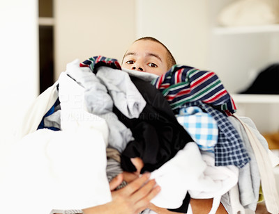 Middle aged man holding pile of clothes at home