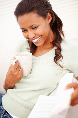 Happy woman having a cup of tea, reading a magazine