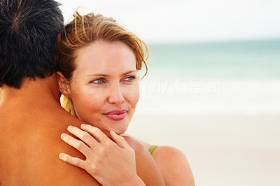 Pretty woman hugging her husband while at the beach