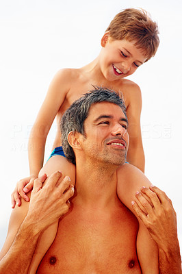 Father carrying his son on the shoulders over a bright background