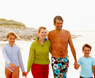 Happy family on a vacation, strolling on the sea shore