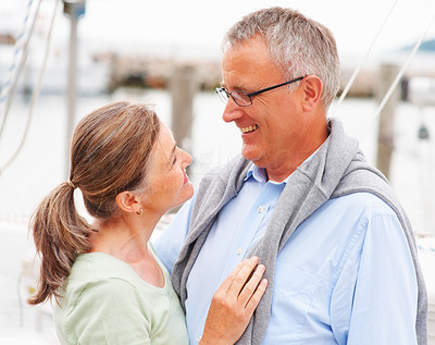A happy old couple looking at each other on sailboat