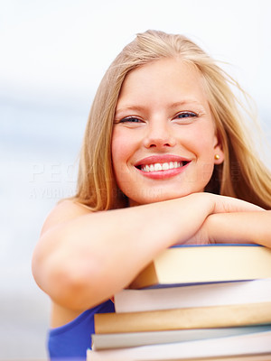 Cute female lying on a stack of books