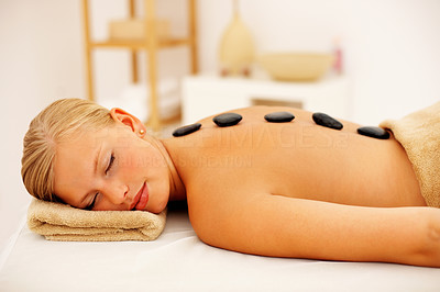 Beautiful woman getting pampered with stone therapy