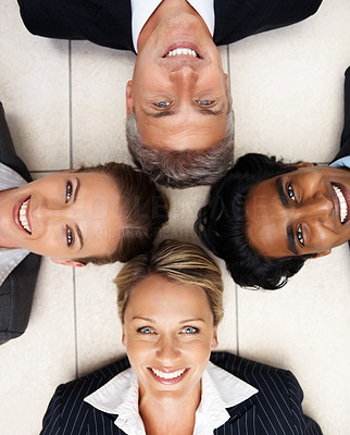 Happy team of colleagues smiling while lying on the floor