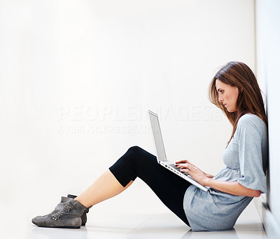 Young woman sitting on floor working on a laptop