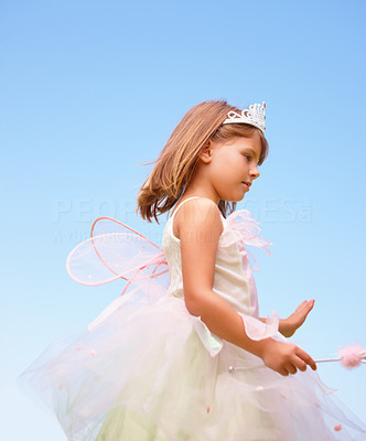 Happy little girl wearing fairy wings against the blue sky