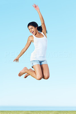 Happy young female jump high into the air