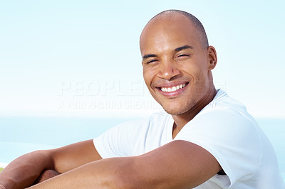 Young man smiling against the sky