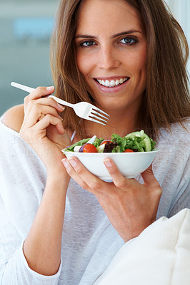 Charming young woman eating green salad