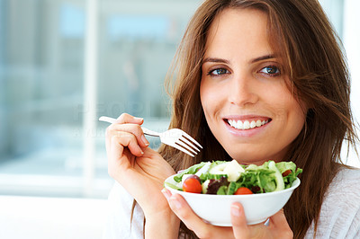 An attractive young woman eating fruit salad