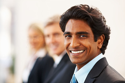 Indian business man smiling with his colleagues at the back