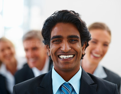 Happy Indian ethnic business man with coworkers at the back