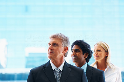 Business people in a line looking away, over blue background