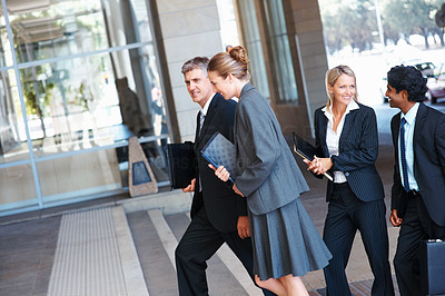 Group of business colleagues walking into their office building
