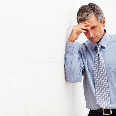 Senior business man with a head ache against a wall