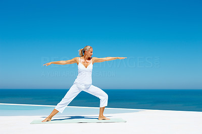 Full length image of an old woman practicing martial arts at the beach
