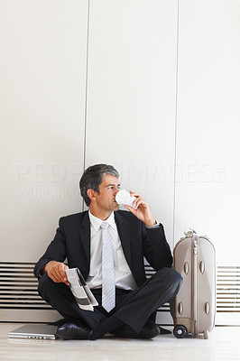 Waiting: Business man drinking tea while sitting on the floor