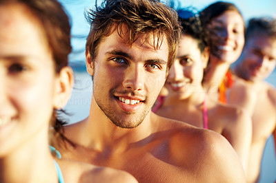 Young guy in a line with group of friends at the beach