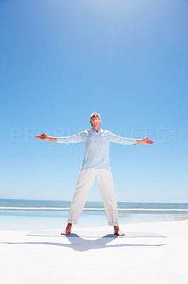 An old man with hands stretched, standing on the beach