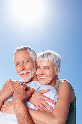 Mature woman with her arms around her husband, outdoors