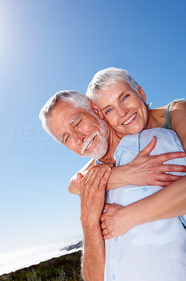 Senior woman with her arms around her husband, outdoors