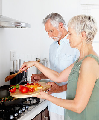Portrait of an elderly couple cooking food together