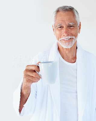 A cheerful handsome old man holding a cup of coffee and smiling